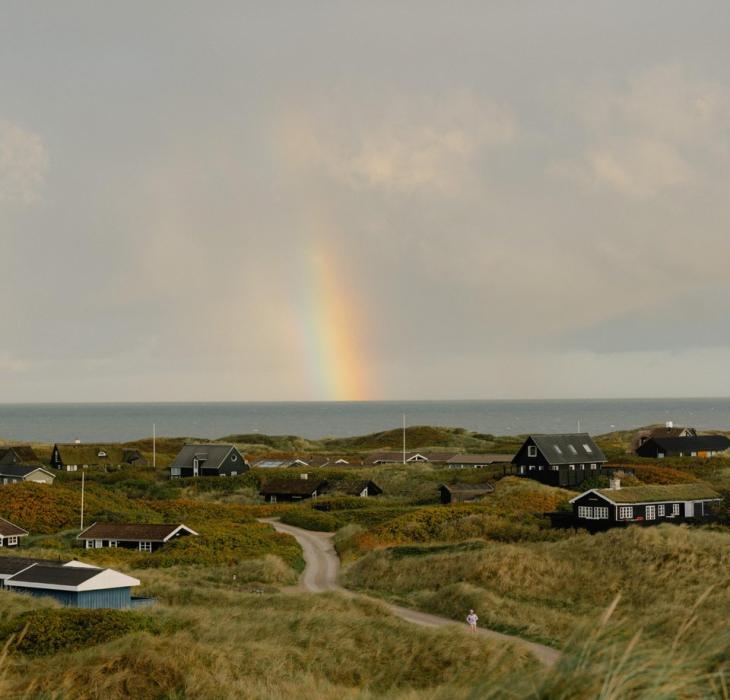 Ferienhaussiedlung an der dänischen Westküste mit Regenbogen
