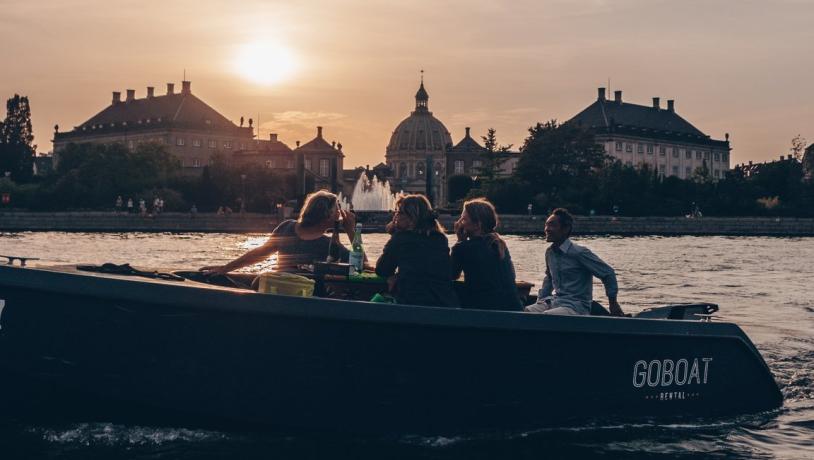 "GoBoat"-Boot bei Sonnenuntergang im Hafen von Kopenhagen