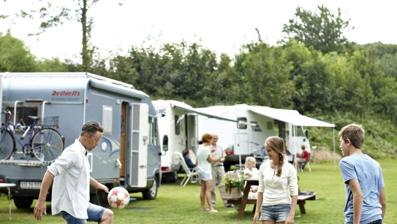 Family playing football at camping site