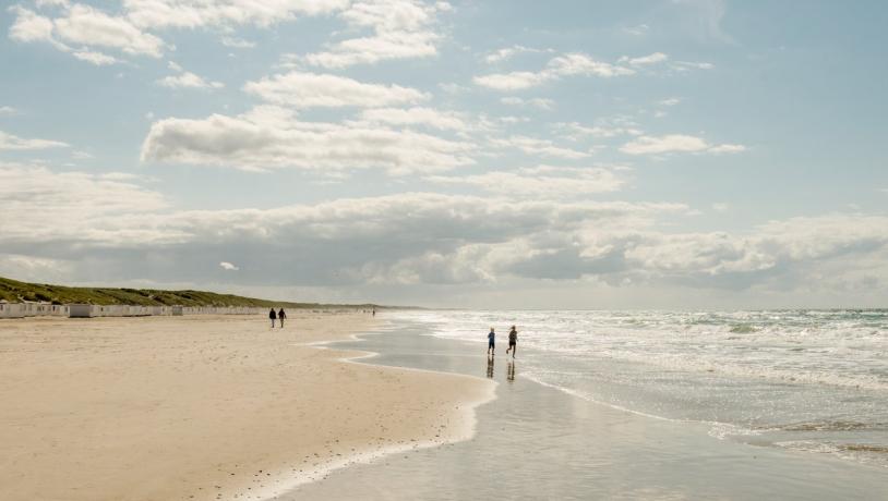 Kinder spielen am breiten Sandstrand von Løkken in Nordjütland an der Dänischen Nordsee