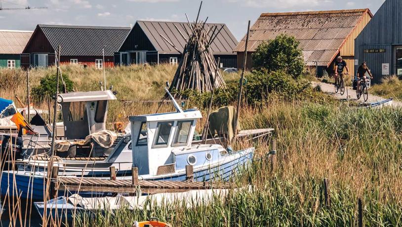 Ein Bild von dem Hafen "Tyskerhavnen" in Hvide Sande mit Fischerbooten und Häusern im Hintergrund