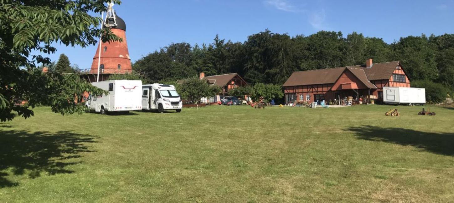 Ein Bild von einem Pintrip Stellplatz, das einen Hof, eine Mühle und zwei Autocampers zeigt