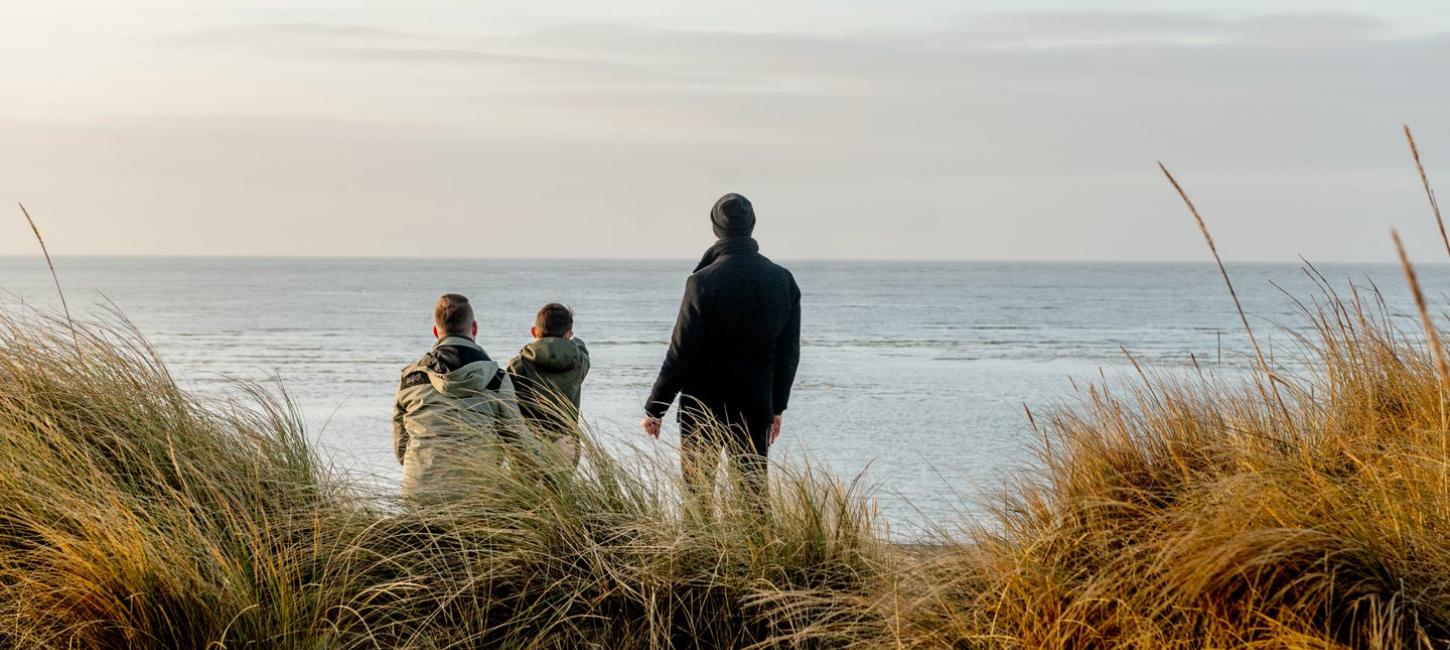 Familie ser utover havet på Blåvand strand, Vestjylland