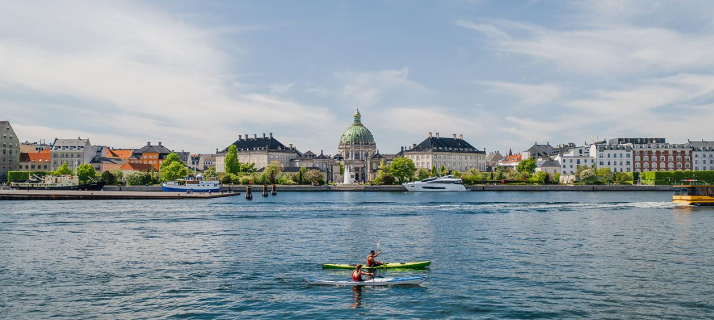 Picture of a kayak on the sea with Copenhagen in the background