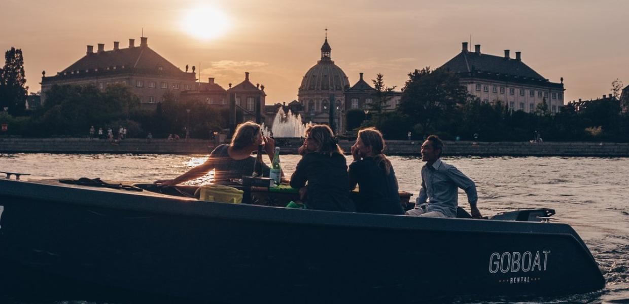 "GoBoat"-Boot bei Sonnenuntergang im Hafen von Kopenhagen