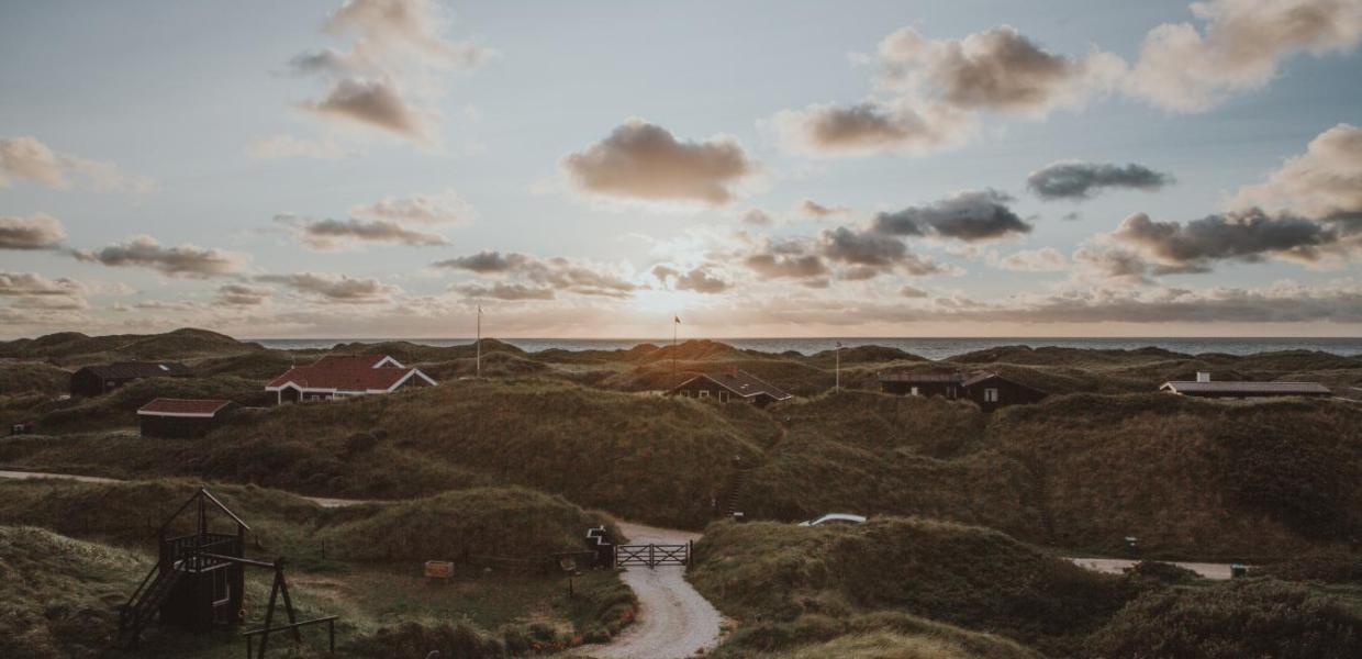 Ferienhäuser bei Sonnenuntergang in den Dünen von Løkken an der Dänischen Nordsee