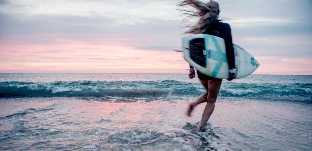 Surfer surfing at Klitmøller at sunrise, North Jutland