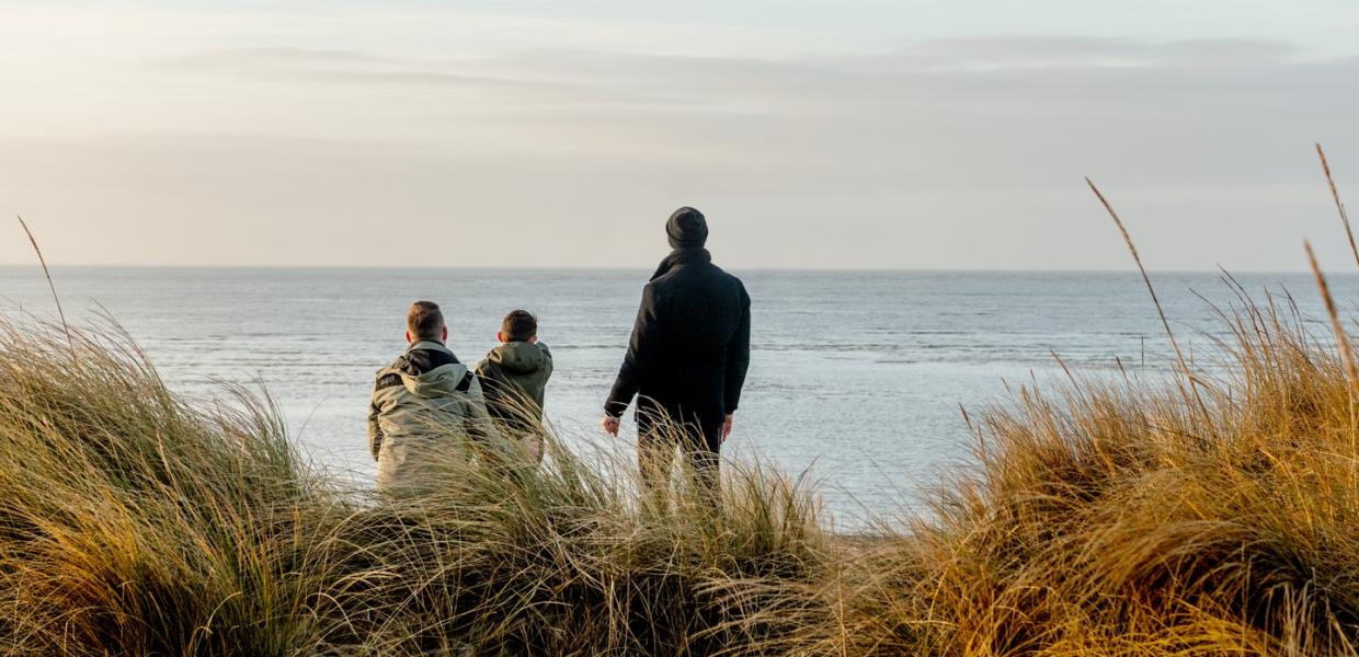Familie kijkt naar de zee bij Blåvand strand, West-Jutland