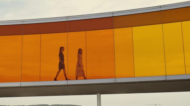 Two people walking in Your rainbow panorama, ARoS Aarhus Art Museum