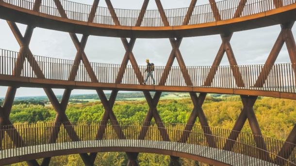 A man walks up Camp Adventure, a forest tower in Denmark.