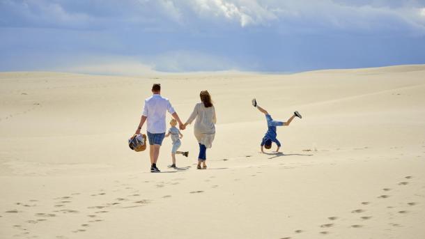 En familie som går gjennom Råbjerg Mile i Nordjylland