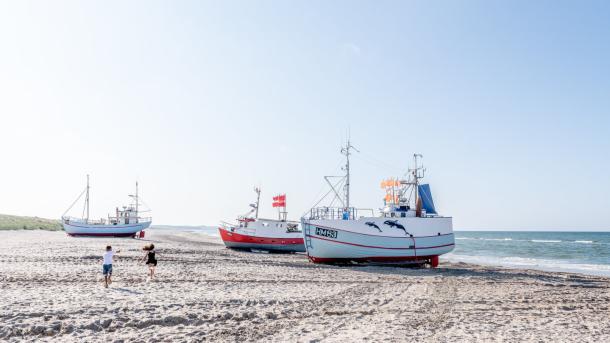 Kinder spielen an der dänischen Nordsee, Fischerboote liegen am Strand