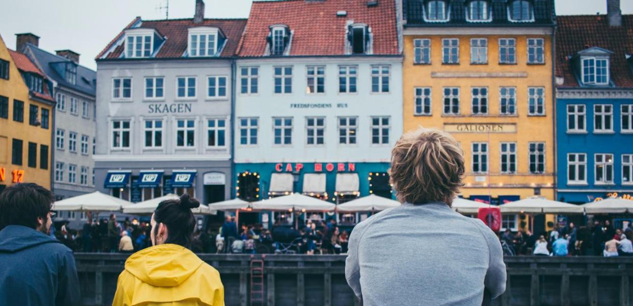 People sitting by the dock in Nyhavn, Copenhagen