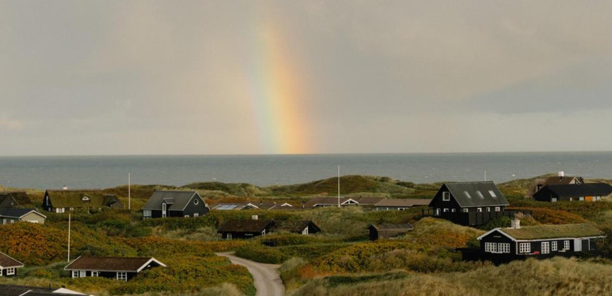 Ferienhaussiedlung an der dänischen Westküste mit Regenbogen