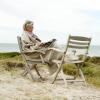 Frau liest in einem Stuhl am Strand in Westjütland an der Dänischen Nordsee