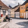 Zwei Freunde auf einer Bank in der Altstadt von Odense auf der dänischen Ostseeinsel Fünen