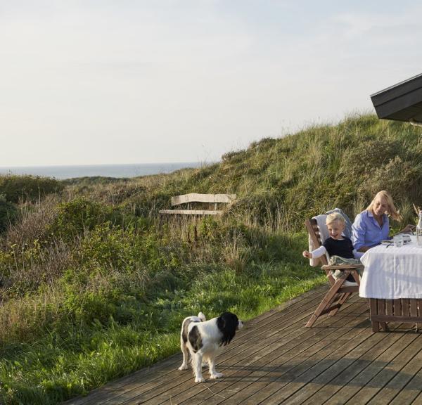 Familie spiser mat utenfor feriehus i Hirtshals