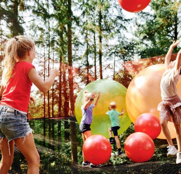 Kinder spielen mit Riesenbällen im WOW Park in Billund