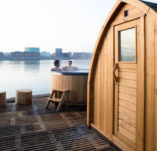 A couple enjoying the hot tub and sauna at CopenHot in Copenhagen