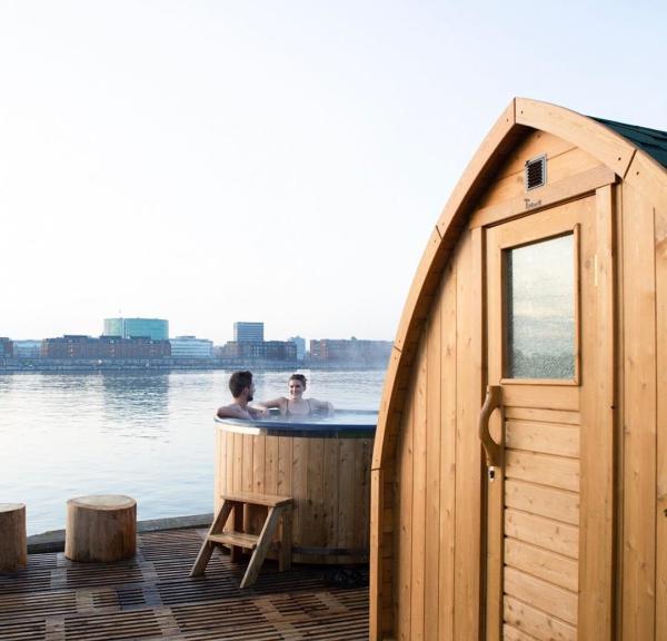 A couple enjoying the hot tub and sauna at CopenHot in Copenhagen