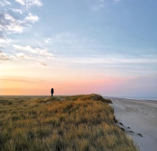 A person hiking along Skallingen on the West coast.