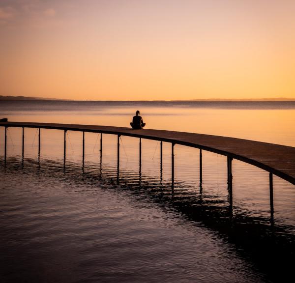 Een vrouw geniet van de zonsondergang vanaf de Infinite Bridge in Aarhus in Denemarken