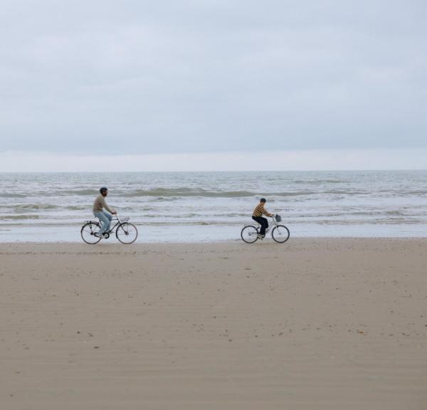 Familie fährt Fahrrad am Strand der dänischen Nordseeküste