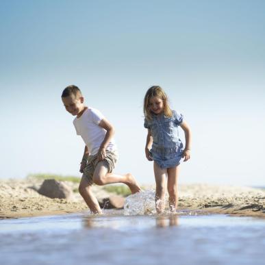 Kinder spielen am Strand auf Bornholm in der Dänischen Ostsee