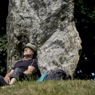 Wanderer macht Rast am Denkmal Skibelund Krat auf dem dänischen Pilgerweg Heerweg