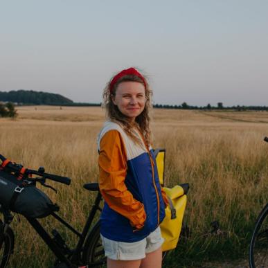 A lady stands with a bike in Hindsgavl National Park, Denmark