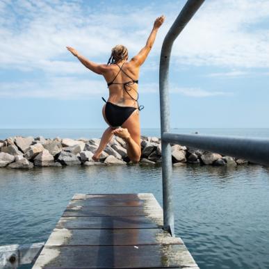 Person jumping in water at Svaneke harbour in Bornholm