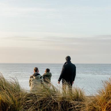 Familie ser utover havet på Blåvand strand, Vestjylland