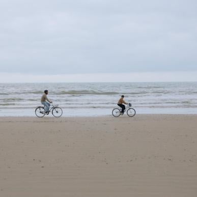 Familie fährt Fahrrad am Strand der dänischen Nordseeküste