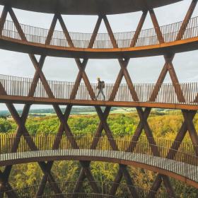 A man walks up Camp Adventure, a forest tower in Denmark.