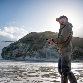 Angler steht im Wasser bei bei Møns Klint, Dänemark