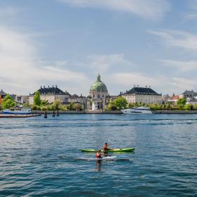 Picture of a kayak on the sea with Copenhagen in the background