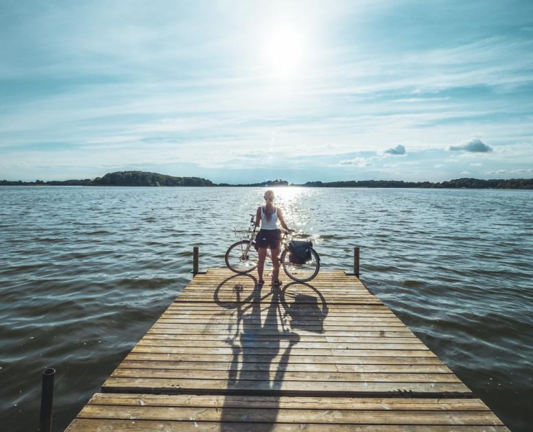 Cyclist standing at Soendersoe lake in Maribo, Lolland-Falster