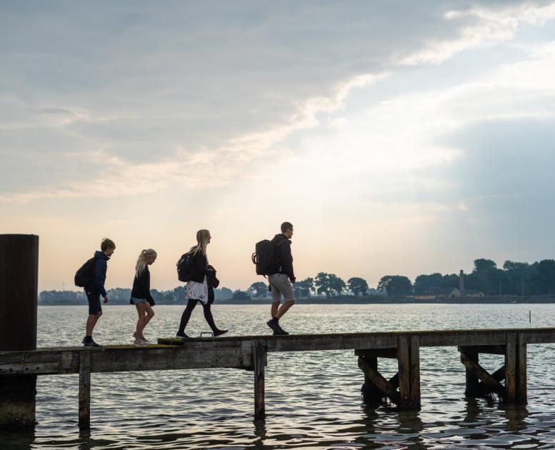 Family walking on a wooden bridge on the island Endelave