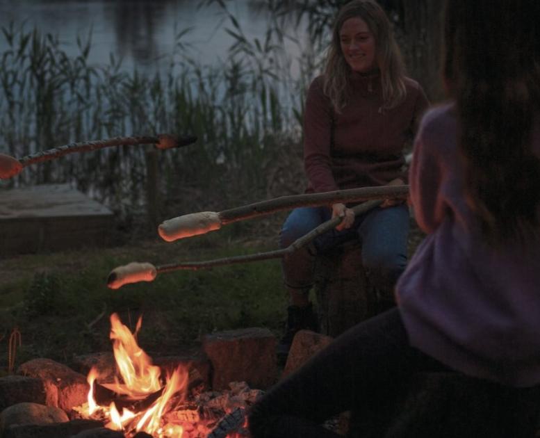 Family baking bread above a campfire