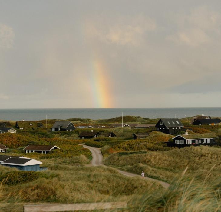 Ferienhaussiedlung an der dänischen Westküste mit Regenbogen