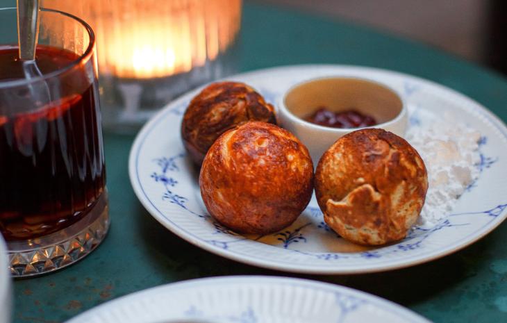 Der dänische Klassiker Æbleskiver auf einem Teller mit Gløgg